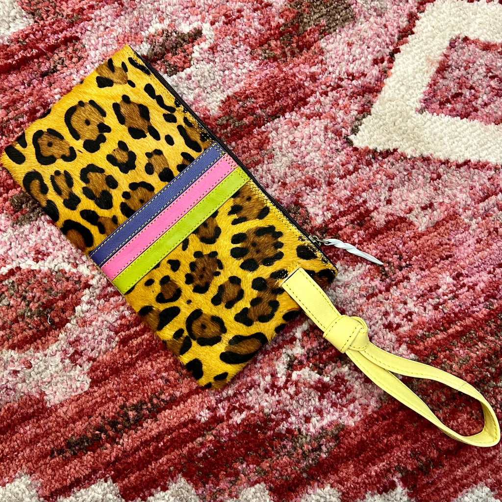 Make a statement with the Lyla Leather Wristlet. Crafted with a leopard print hair on hide, and a vibrant leather strip detail, this wristlet is the perfect accessory for the wild at heart. With an 8" yellow leather handle, zipper closure, and card slots inside, you can get a good grip on your things! (9"W X 5"H)