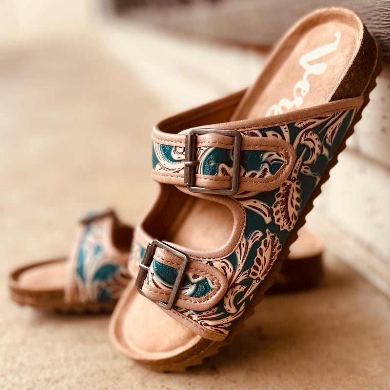 Treat your feet to a touch of luxury with these Berry Comfy Turquoise Burkies! Featuring a double strap and an intricately tooled floral pattern with a beautiful turquoise painted leather, these stylish sandals will step up any outfit - not to mention their super comfort! Slip into these tan leather gems and make heads turn!