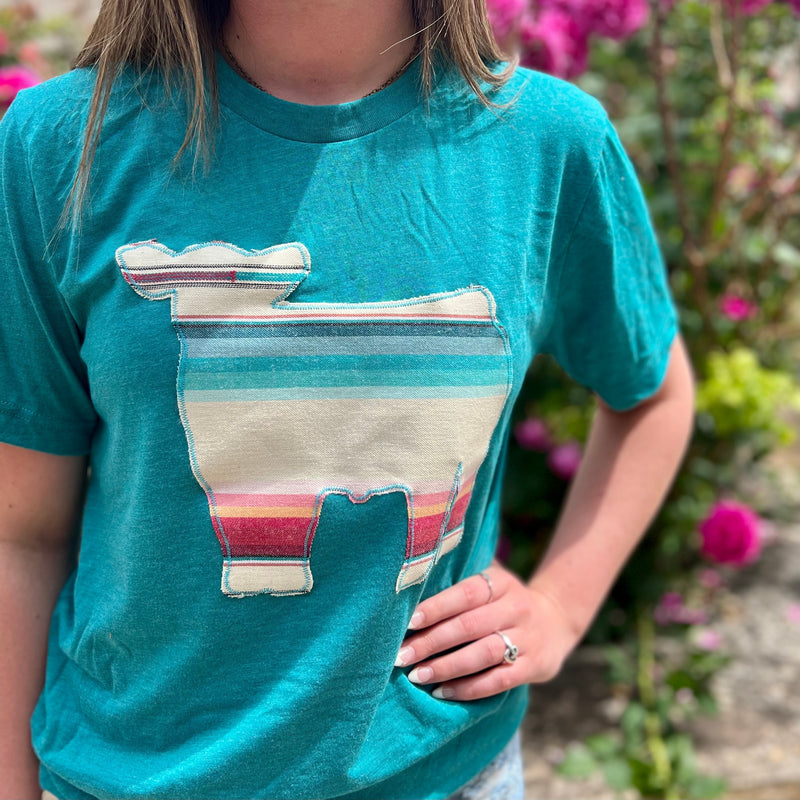 Look stylish and make a statement with this PLUS Cow Calling Tee! Featuring a bold dulce serape cow print, this premium quality crew neck tee is crafted with a blend of 50% Polyester, 25% Cotton, and 25% Rayon for all-day comfort and breathability. The vibrant teal colored short sleeve makes a statement for any occasion.