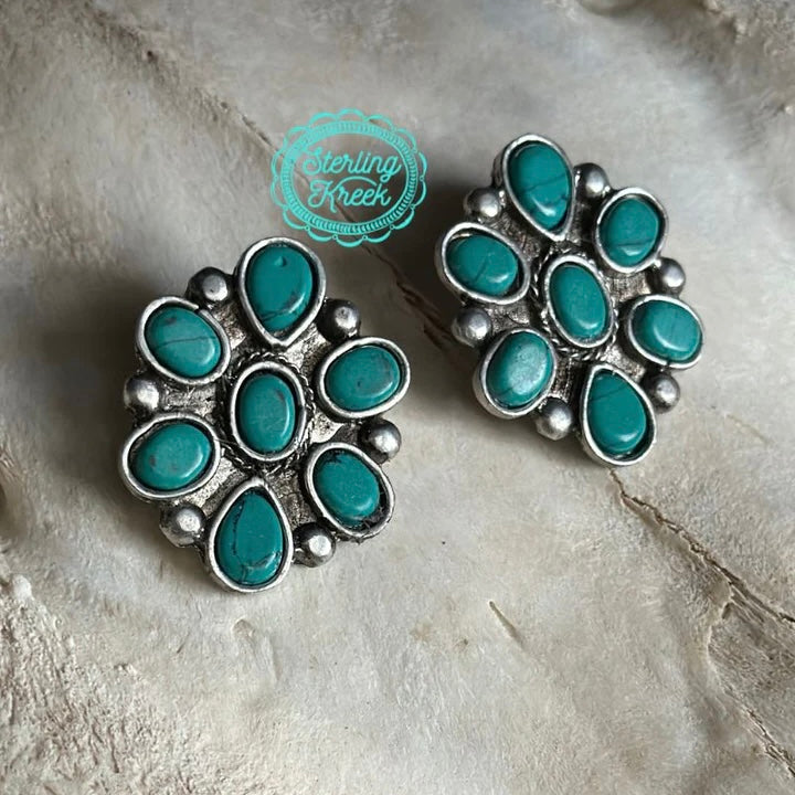 Make a statement with the Seven Seas Earrings! These earrings feature an enchanting flower-shaped design and seven turquoise stones that will make you stand out. Be the life of the party and add some color to your look - these beauties are sure to turn heads!