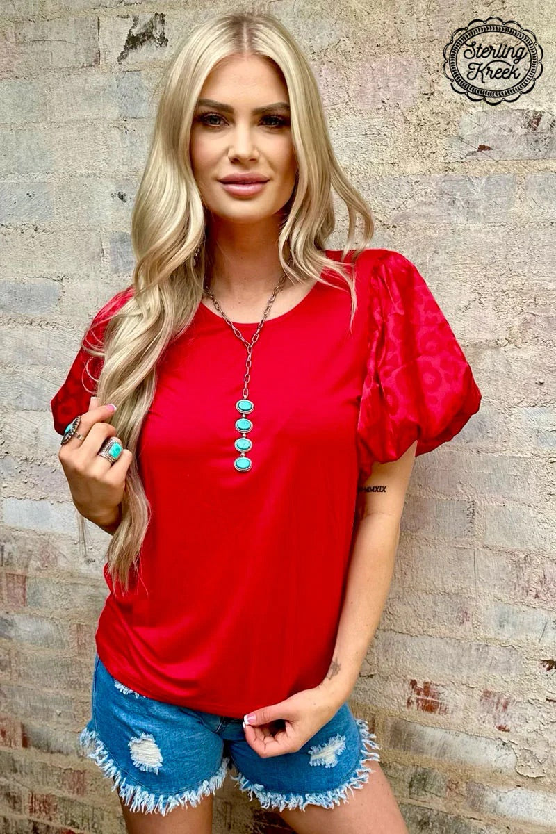 Look wild in the red cheetah Louisiana Woman Top! This fashion-forward top features luxurious bubble sleeves, ensuring that you make a statement wherever you go. Rock this unique style and let the world know you mean business!