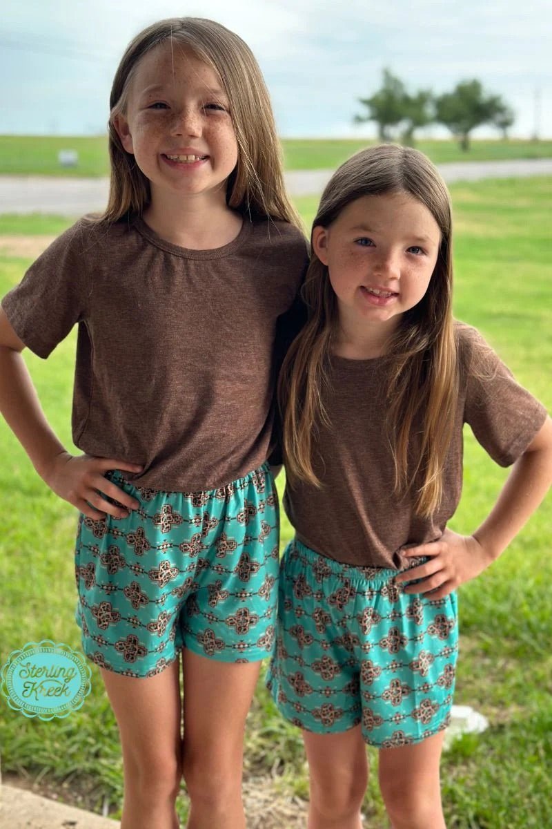 Let your little trendsetters show off their wild side in our On The Border Shorts Kids! Featuring an elastic waistband adorned with a cheetah aztec print, these turquoise shorts are perfect for days that call for wearing your most stylish (and fun!) outfit. Roar your way into style!  KoDee is wearing a Small  KyLee is wearing a Medium  96% Polyester 4% Spandex