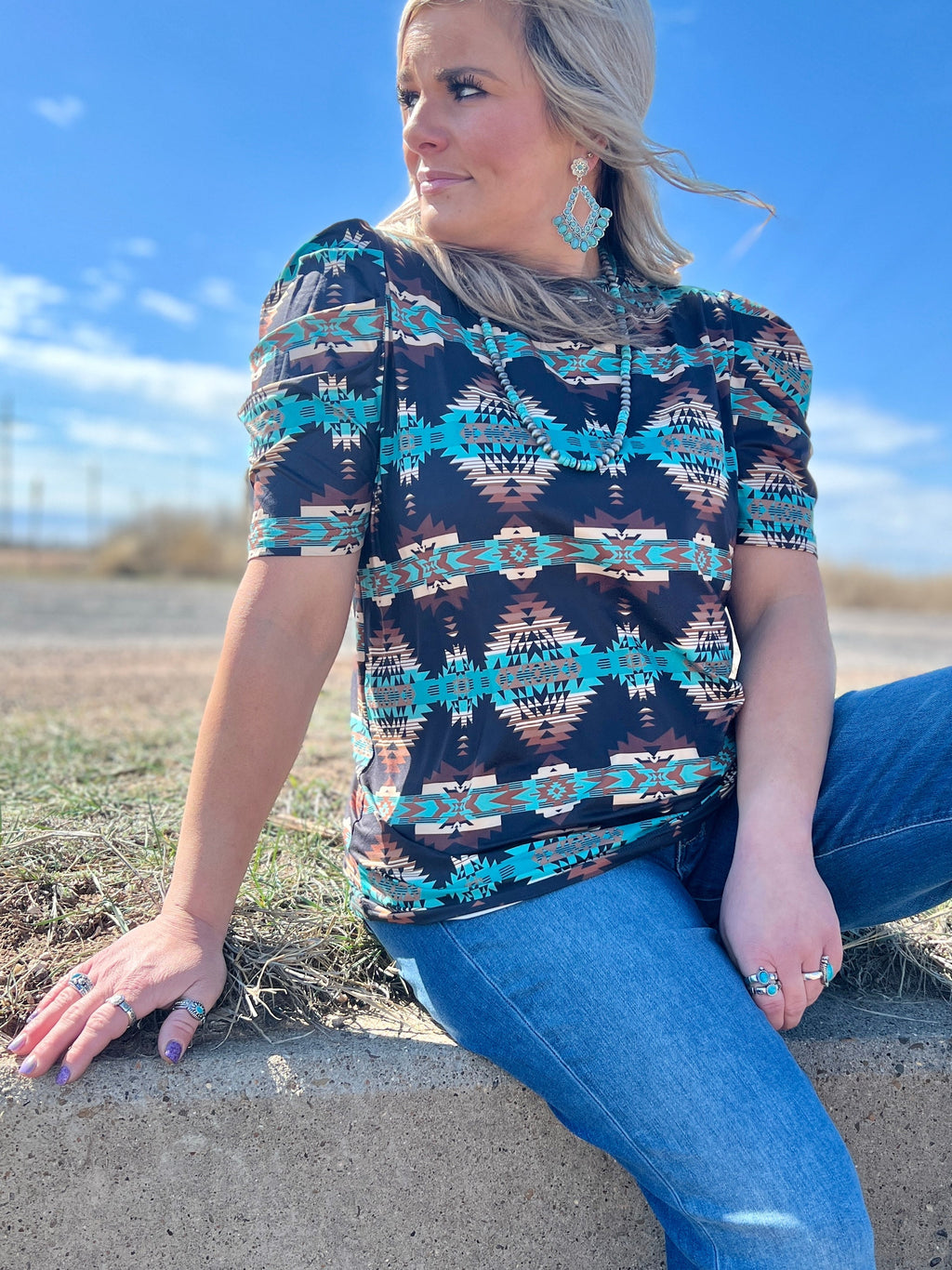 Sterling Kreek Bermuda Bubble Top. Trending western outfits. Trending fashion 2024. Women's aztec short sleeve top. Turquoise aztec top. Bubble sleeve top. Western fashion. Western style. Western outfit. Rodeo top. High neck western top. Southwestern style top. Women's western shirts. Small business. Woman owned.