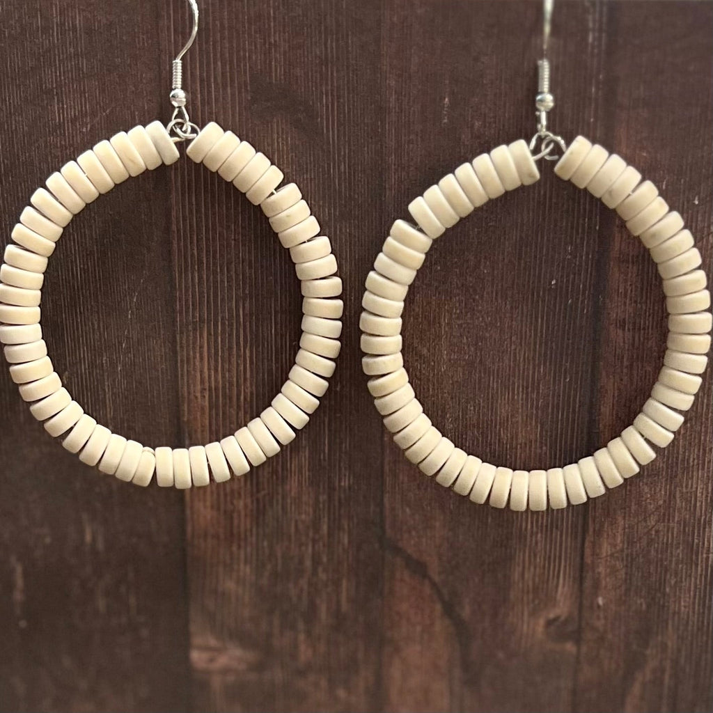 Make a statement with these stylish Disc Bead Hoop Earrings! Crafted with ivory seed beads and a fish hook dangle, they add a touch of elegance to any look. Pair these chic and timeless earrings with your favorite ensemble for a look that's sure to turn heads.