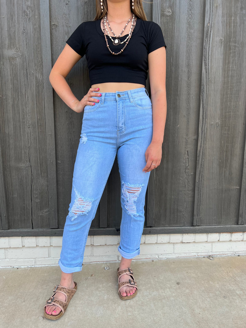 Be the definition of effortless style with the Perfectly Balanced Denim. These high-waisted mom jeans feature shredded knee holes and a distressed hem, plus a button closure and zip fly. Rock 'em with a tucked-in blouse and statement earrings for a look that won't even break a sweat! Five pocket styling, high rise light wash denim—it's jeans perfection!