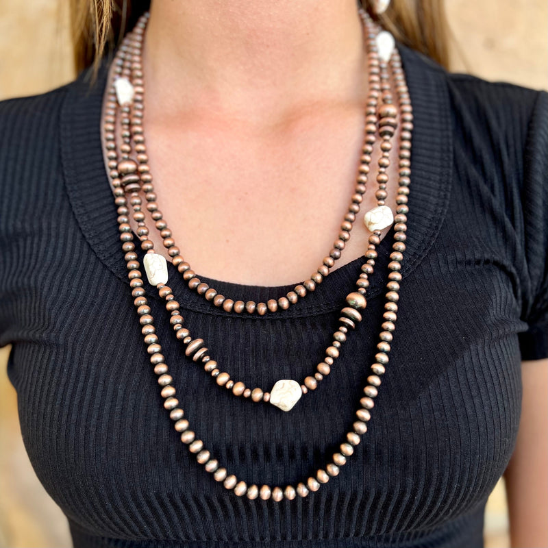 This elegant and timeless Classic Stone Necklace is perfect for those who value classic sophistication and style. Its triple-layered copper beaded design with ivory stone accents is sure to add a luxurious touch to your look. With a length of 24" it is perfect for any special occasion.