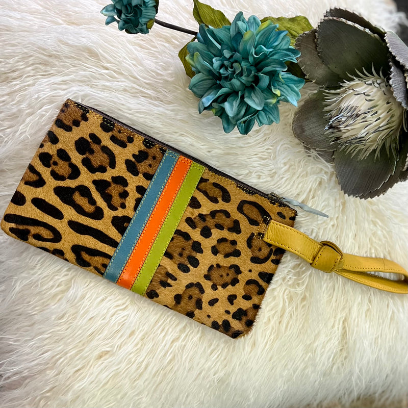 Make a statement with the Lyla Leather Wristlet. Crafted with a leopard print hair on hide, and a vibrant leather strip detail, this wristlet is the perfect accessory for the wild at heart. With an 8" yellow leather handle, zipper closure, and card slots inside, you can get a good grip on your things! (9"W X 5"H)