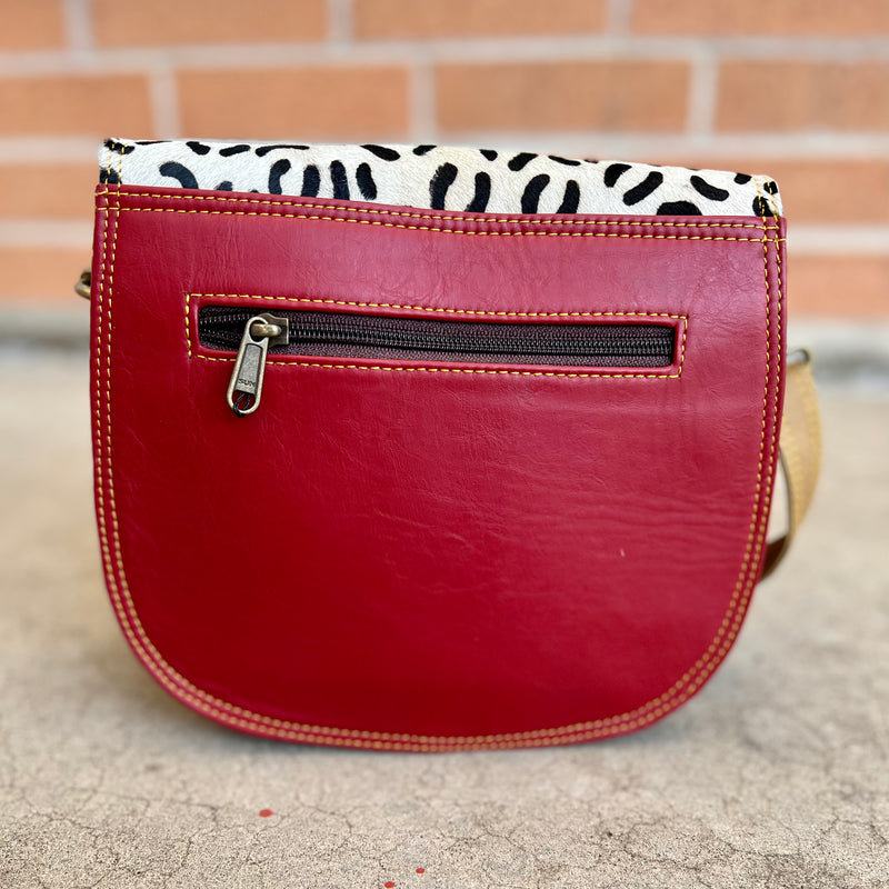 Let your style shine with our Talia Crossbody Bag! Featuring an eye-catching explosion of colors and textures with 36" adjustable/removable strap, multi color leather strip detail, hair on hid fold over flap and so absolutely colorful. You'll be the envy of everyone you encounter with this showstopper accessory! 1 inside compartments with an inside back zipper pocket, and a snap front pocket to hold all your essentials!  8.5" W X 7" H in size.