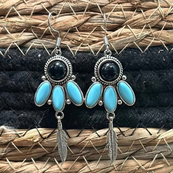 These Birds Eye Earrings are the perfect accessory to complete any outfit. With dangle style and a feather that sways with your every move, you'll never be out of fashion. Flaunt your style with three unique turquoise stones and a black stone - it's the ultimate feather in your cap!  length: 1.5"