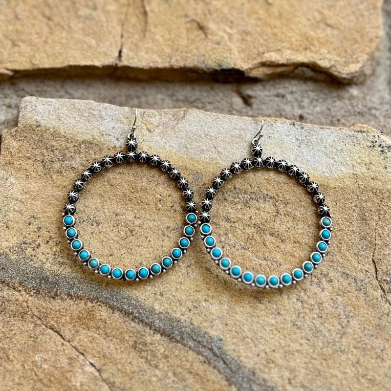 Make a statement with the Center of My Universe Hoops. The intriguing combination of a silver dangle and a turquoise stone, set in a 2" hoop, creates a work of art for your ears. With a 2.5" length, these hoops bring a hint of glam to your style that will make you the center of your universe.