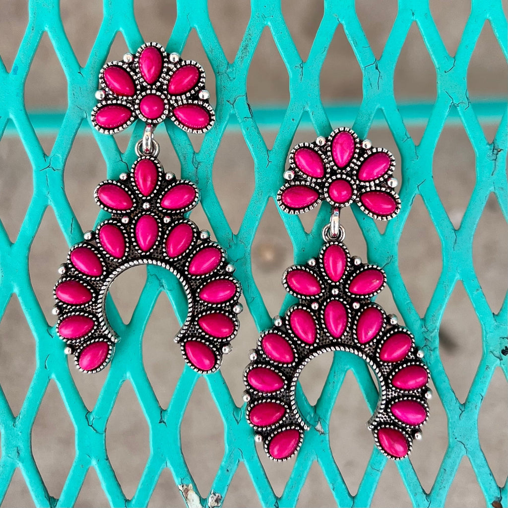Look like royalty with our Crowned in Pink Earrings. Handcrafted with a pink stone set in luxurious silver, these elegant accessories feature a mini squash design and dangle 2" from the post back. Make a refined statement with these exquisite earrings.