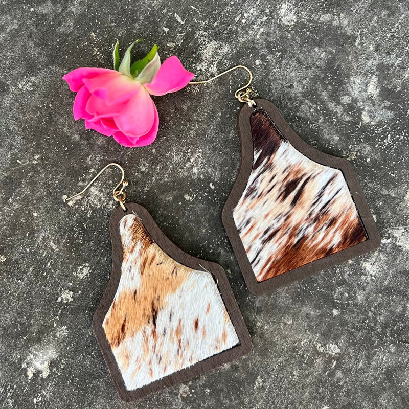 Crafted from smooth brown wood and featuring luxurious faux cow print hair on hide, these dazzling Cattle Co. Earrings make a statement of sophisticated elegance. Choose from two color combinations – brown and white or tri color – each measuring 2.5" in length and finished with a dangling style. Flaunt these timeless accessories with any look for a touch of timeless, luxurious style.
