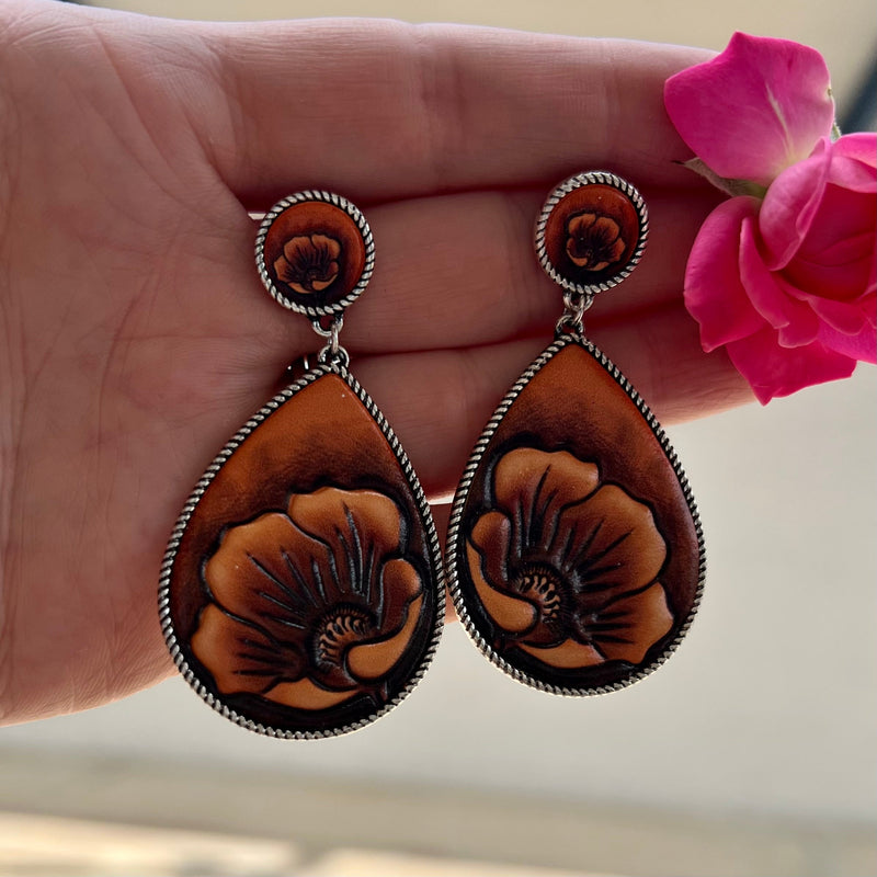 Indulge in these luxurious floral-stamped dangle earrings, crafted with soft brown leather and finished with a high-shine silver plate. Perfect for lending a subtle elegance to your look, their 2-inch length adds an ideal finishing touch.