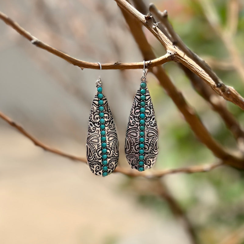 Beautifully crafted for a timeless look, the Give It To Me Straight Earrings are the perfect pick for a night out. Available in two color choices - silver and turquoise or copper and ivory - these earrings feature elegant paisley stamping and gently dangle 2.5" for a sophisticated, refined statement.