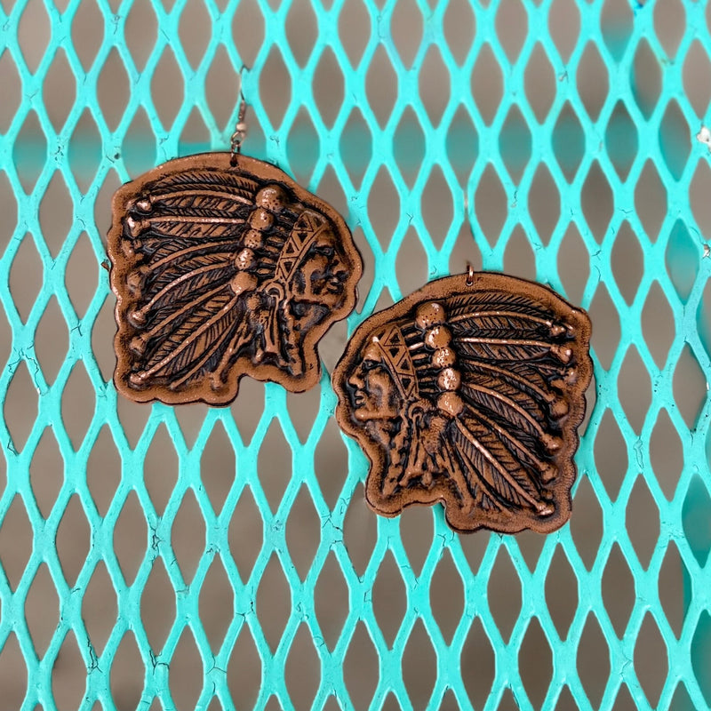 Adorn your ears with the sophistication and elegance of our Leather Chief of Chiefs Earrings. Crafted from luxurious leather, these dangle earrings feature a fish hook design and are adorned with an impressive 3" Indian chief leather stamp. Elevate any ensemble with these tasteful yet stylish earrings.
