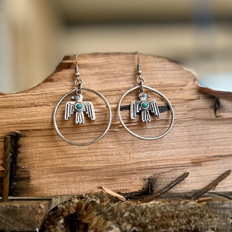 Complement your chic, western style with our Leave the Nest Earrings. These eye-catching accessories feature silver thunderbird and turquoise stone dangles on stunning, silver hoop backings. A fish hook closure ensures a secure fit, while the earrings hang 2” in length. Strut around with effortless elegance wearing these memorable earrings.