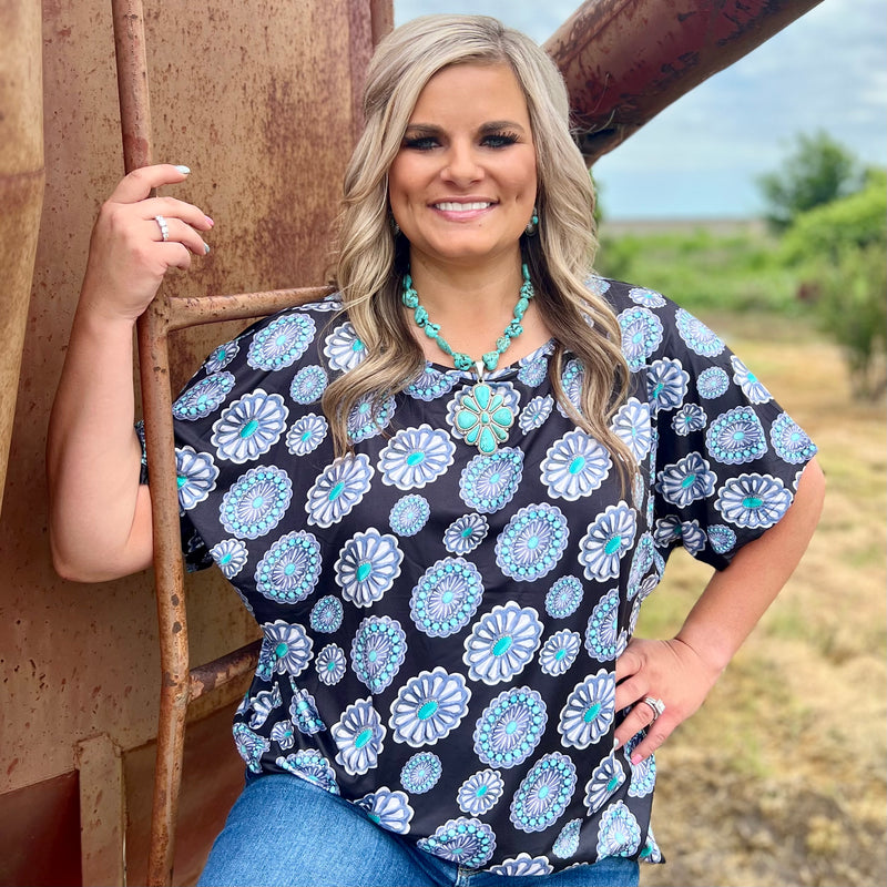Lasso the look of the season with this stylish Concho Top. Its wide-cut short sleeves and round neckline give it a laidback western spin, complete with sparkling conchos. Perfect for any rodeo-ready look! Yee-haaa!