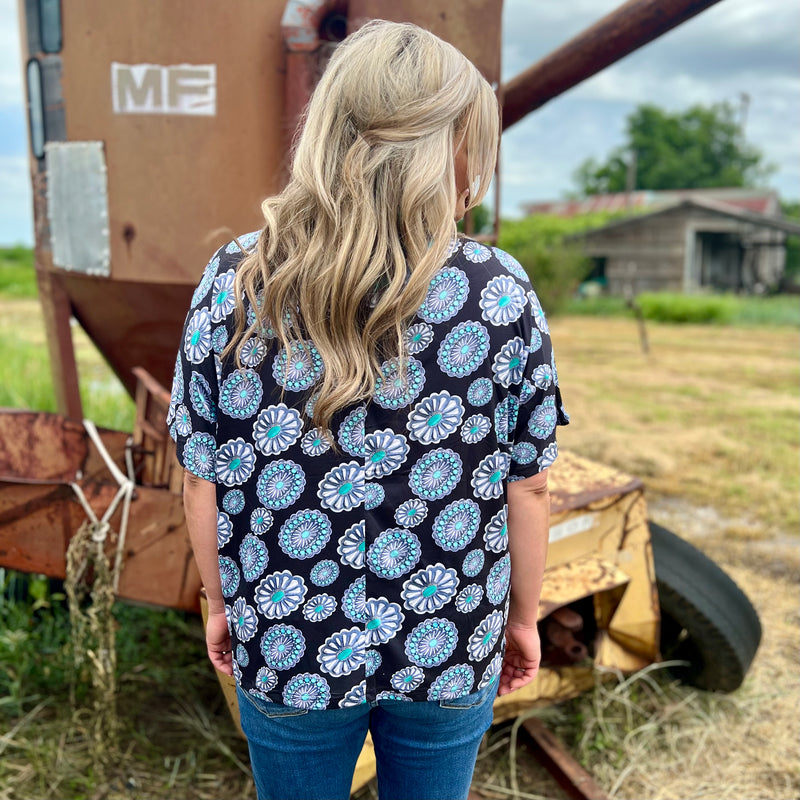 Lasso the look of the season with this stylish Concho Top. Its wide-cut short sleeves and round neckline give it a laidback western spin, complete with sparkling conchos. Perfect for any rodeo-ready look! Yee-haaa!