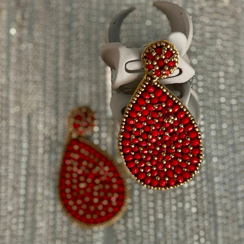 These Seed Bead Tear Earrings dazzle with intricate craftsmanship and opulence. The earrings feature a layered tear drop shape made from glass seed beads in four different colors - multi, red, black & turquoise - along with glass crystal beads. The final touches of the dangle design include a post back and a length of 3" to gracefully frame your face. Showcase your flawless style with these beautiful earrings.