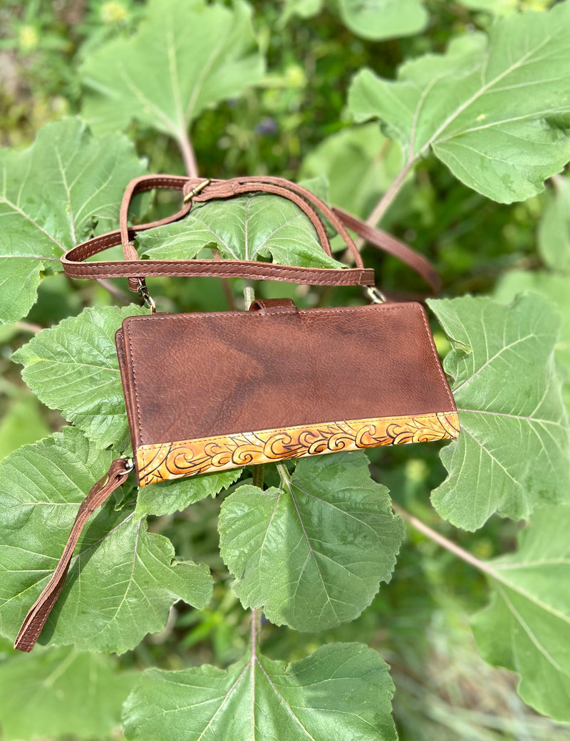 Introducing the Longhorns Horizon Wallet: your stylish, quirky companion on the open plains! This 8"W X 4"H crossbody wallet comes with a 50" adjustable and removeable strap, so you can easily secure it while you're running wild. Plus, it's got a hand painted long horn steer design, fold over snap closure, and multiple card slots and inside zipper compartment to store all your loot! Saddle up!