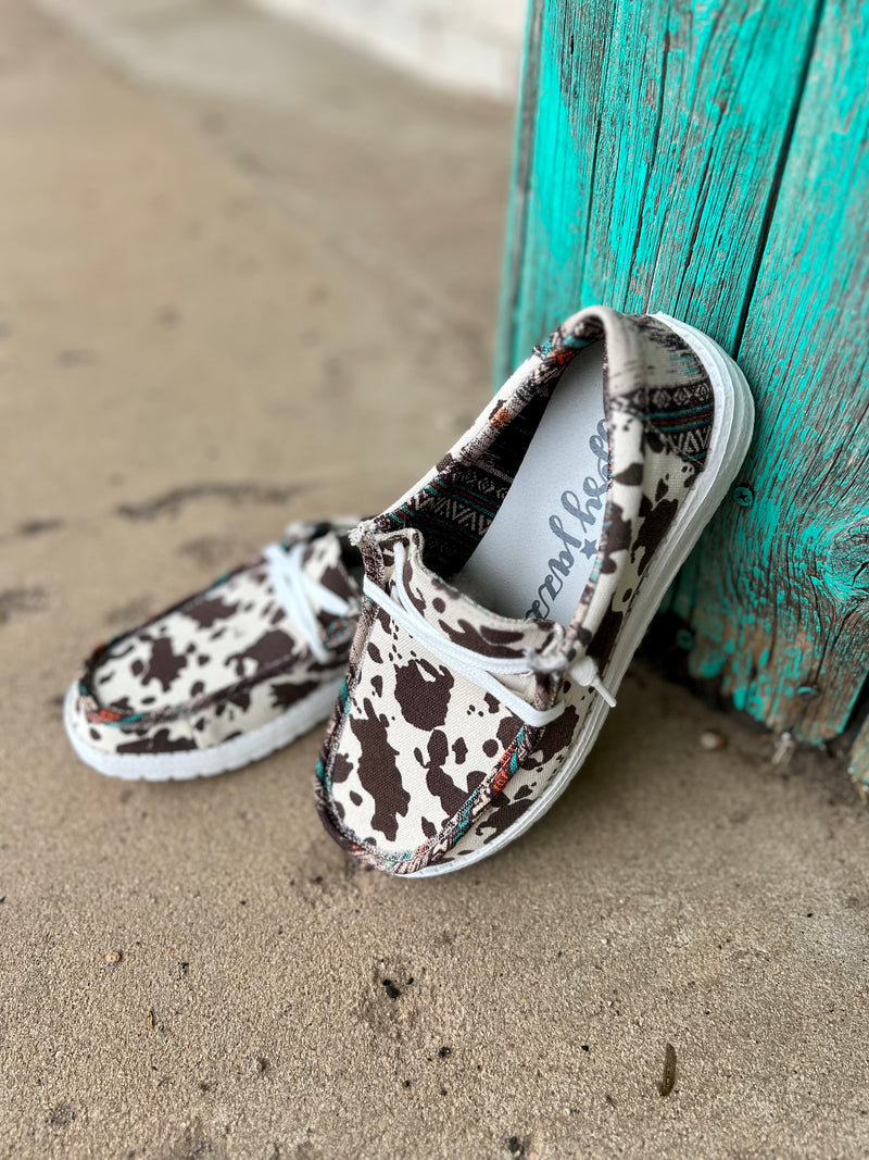 Introducing the Brown Cow in a Meadow Loafers. Gracefully crafted with a brown and white cow print for a timeless look, and a vibrant multi-colored aztec print to add a splash of character. Slip on with ease and a comfort sole for a luxurious, relaxing fit. All together, these shoes offer a beautiful and comfortable look for any occasion.
