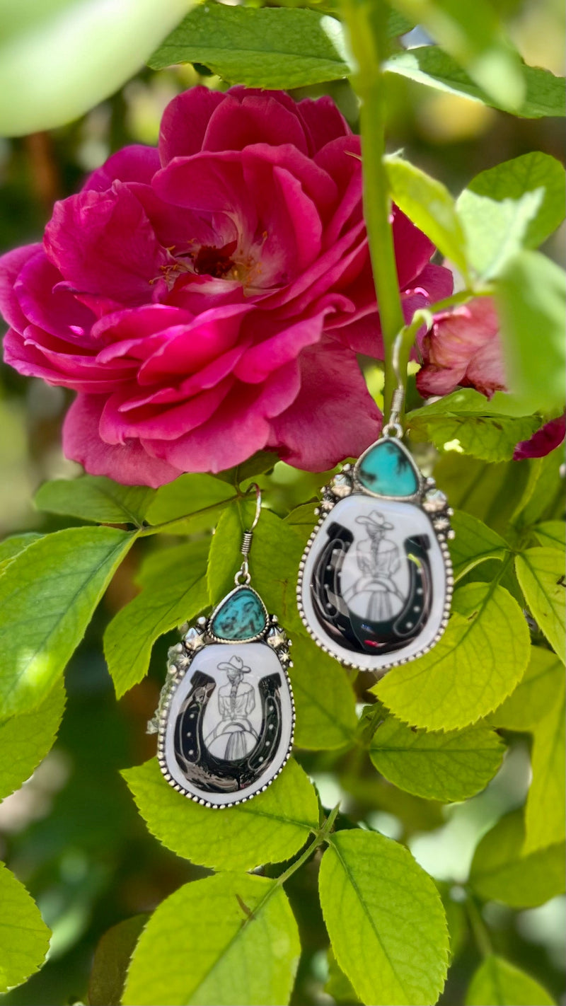 Add a hint of the wild west to your outfit with these Sophisticated Cowgirl Earrings! Crafted of high polish silver with a western concho, horse shoe print, and a black & white contrast, these dangly earrings are sure to lasso some attention. Yee-haw!