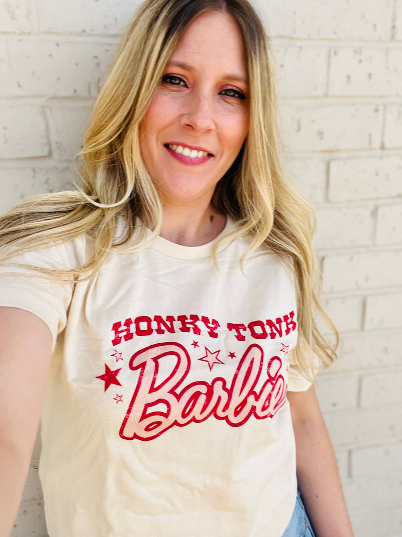Put your honky tonk style on display with this comfy cotton Barbie graphic tee! With a playful tan and red color combo, plus the classic crew neck and short sleeves, this Barbie tee is a fashion grand slam.  Let the party begin!