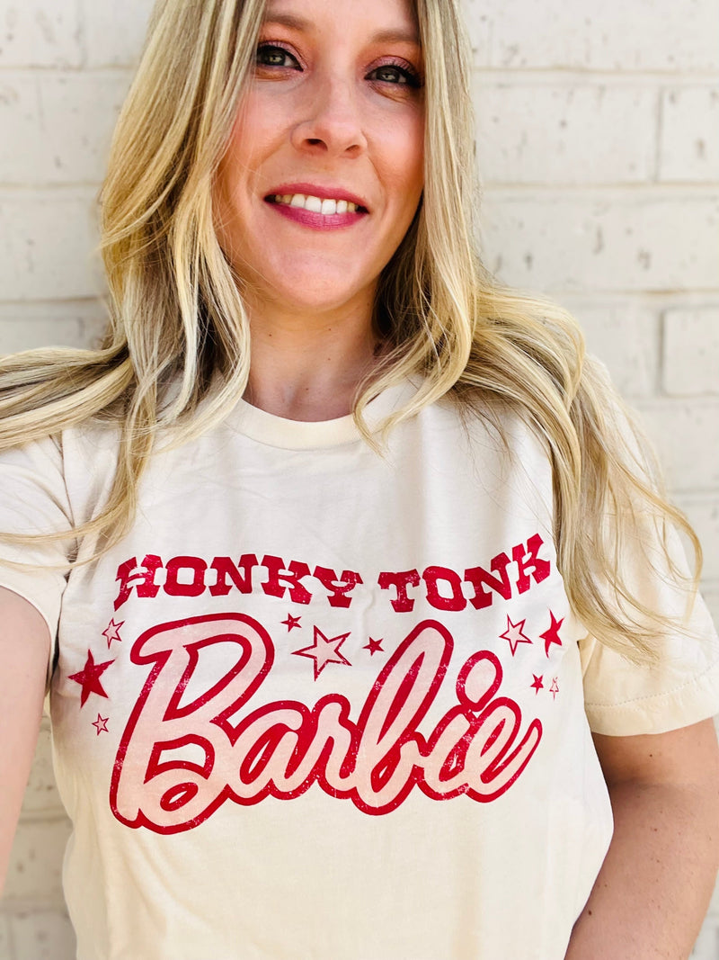 Put your honky tonk style on display with this PLUS size comfy cotton Barbie graphic tee! With a playful tan and red color combo, plus the classic crew neck and short sleeves, this Barbie tee is a fashion grand slam.  Let the party begin!