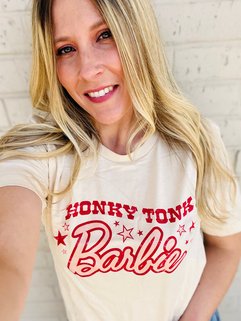 Put your honky tonk style on display with this comfy cotton Barbie graphic tee! With a playful tan and red color combo, plus the classic crew neck and short sleeves, this Barbie tee is a fashion grand slam.  Let the party begin!