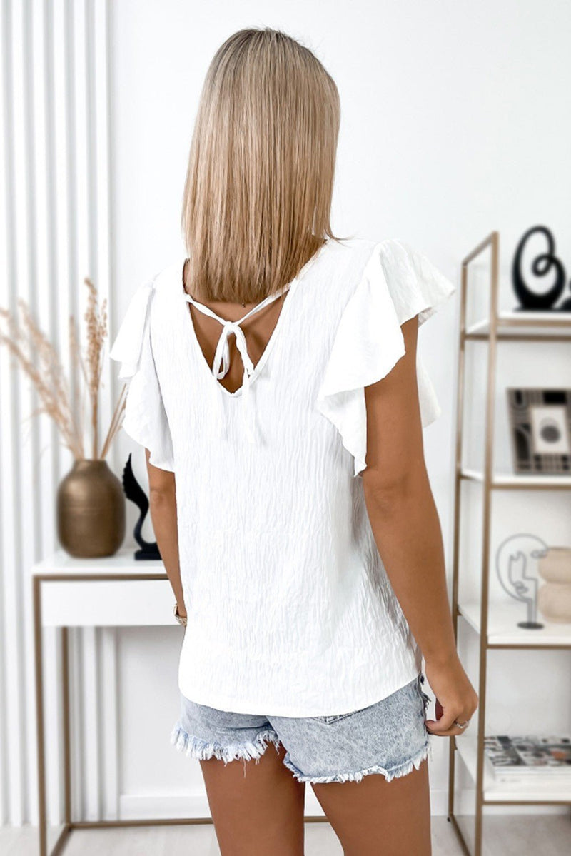 This top is a fashion classic – white in color, stay loose and comfortable in a V-neck, ruffle sleeve, shift fit with a chic back tie design, all made from a comfy soft fabric. Look good, feel good, party on!