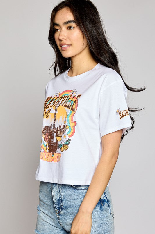 Look rad and show off your country music pride in our Nashville Music City Crop Top! This stylish, white crew neck cropped tee features a cool guitar on a Nashville skyline graphic, making it the perfect choice for any fan of country music. Yee-haw!