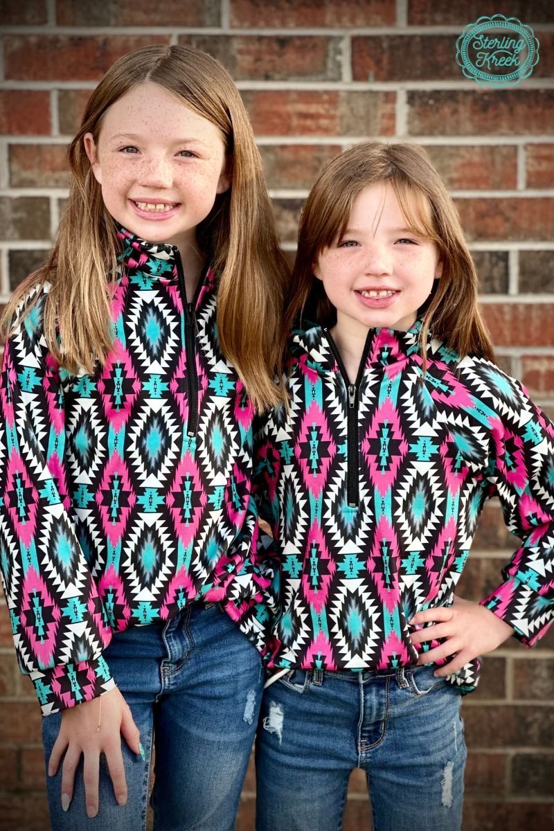 Look sharp in this Mini Montezuma Pullover with its vibrant pink, black, white, and turquoise aztec pattern. Zip up in style and stay cozy in this quarter-zip pullover - no need to sacrifice fashion for comfort!  Kids pullovers are 2 inches longer in the sleeves than last year.  :)  32% COTTON 56% RAYON 12% SPANDEX