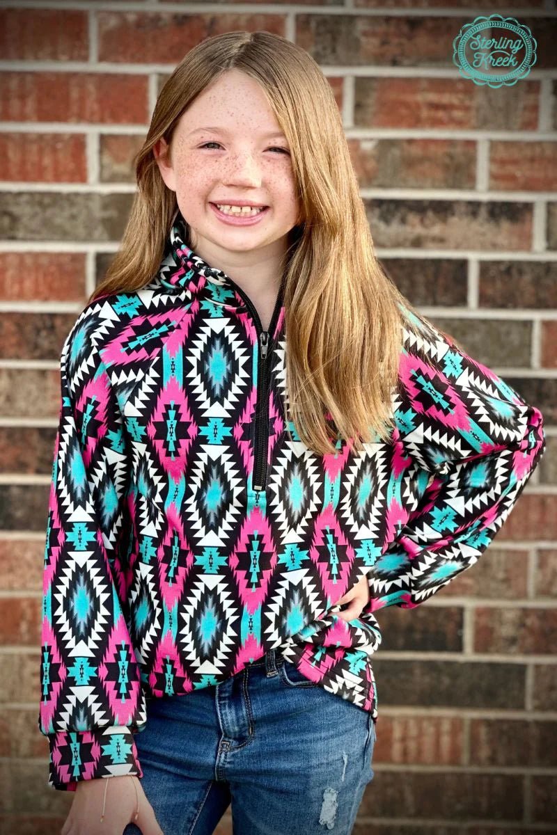 Look sharp in this Mini Montezuma Pullover with its vibrant pink, black, white, and turquoise aztec pattern. Zip up in style and stay cozy in this quarter-zip pullover - no need to sacrifice fashion for comfort!  Kids pullovers are 2 inches longer in the sleeves than last year.  :)  32% COTTON 56% RAYON 12% SPANDEX