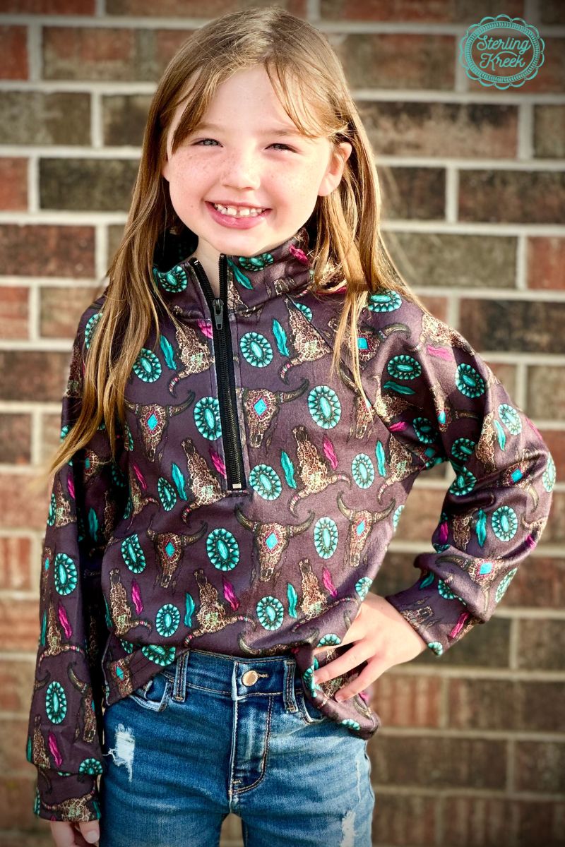 This Mini Wild Thing Pullover puts a chic spin on western style! It's a black pullover with a quarter zip up, designed with cheetah cow skulls and turquoise conchos - talk about a wild ride! This statement piece will have you snazzy-fied in no time!  32% COTTON 56% RAYON 12% SPANDEX