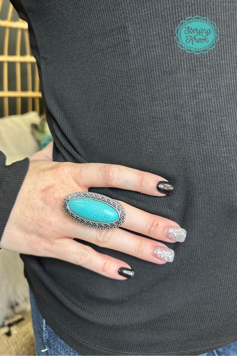 Sparkle your way to the top with our Wear It Loud Ring! This eye-catching accessory features a vibrant turquoise oval stone set in a simple silver ring, sure to make heads turn. Wear it loud and proud and show off your unique style!  Length: 1.75"