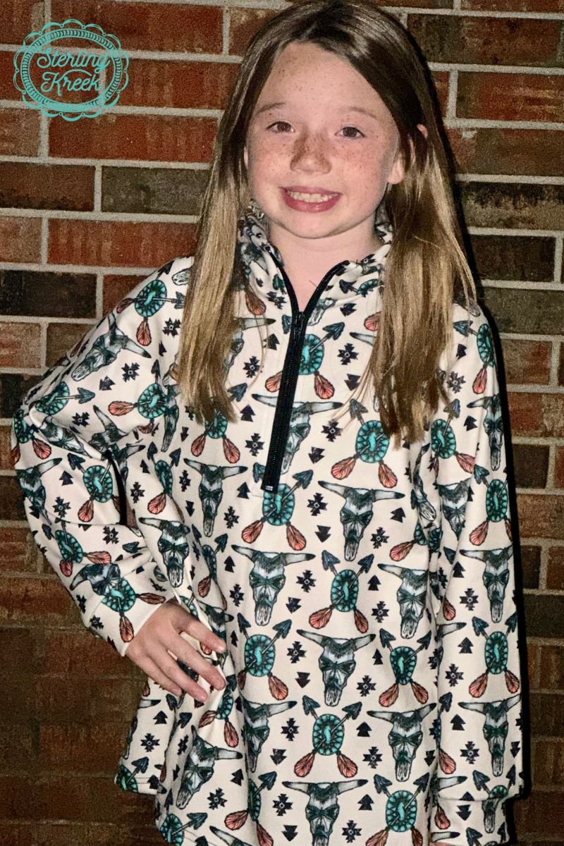 Be the talk of the tribe in this eye-catching Mini Eastern Tribal Pullover! Featuring a cream-colored base and decorated with cowskulls, arrows, and conchos, this is one pullover you'll definitely want to pull out of your wardrobe! Make a statement and grab yours today!  KoDee is in a Medium  KyLee is in a X-Large  32% COTTON 56% RAYON 12% SPANDEX