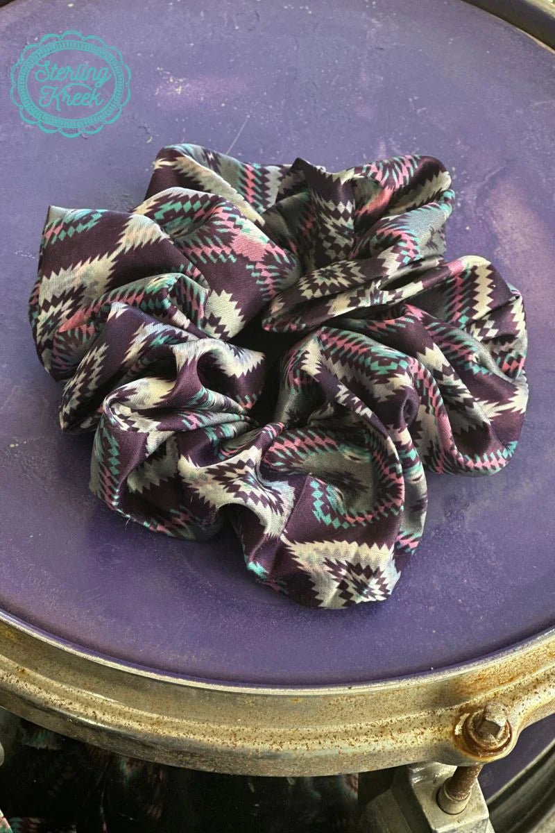 Make a fashion statement with the Tucson City Scrunchie! Show your style with this fun and funky pink and purple aztec silky scrunchie — perfect for all your wildest mane-taming endeavors!  OUTTER WIDTH: 5"  INNER WIDTH: 1.5"
