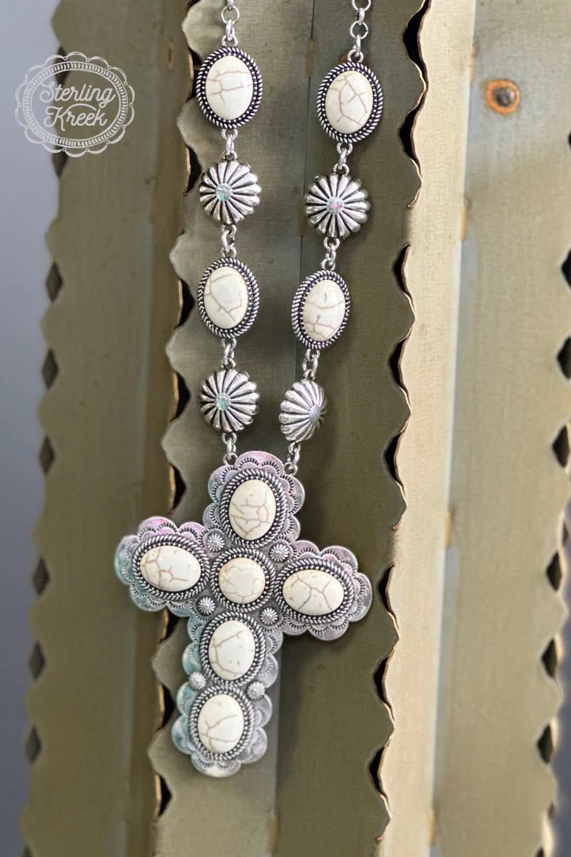 Show your faith in style with this one-of-a-kind Cowgirl Church Necklace! Crafted with a white stone cross, this necklace adds a bit of bling to your faith! Saddle up and treat yo’self, Partner. Yee-haw!  Length: 14"
