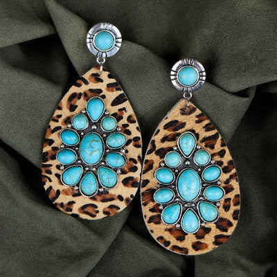 These Wildly Turquoise Tears Earrings are the perfect blend of sophistication and statement. Featuring stunning turquoise flowers, a leopard print hair on hide, and tear drop shapes with a turquoise stud stone, these are drop earrings to elevate any ensemble. Measuring 4" in length, these post back dangles are the perfect way to take any look to the next level.