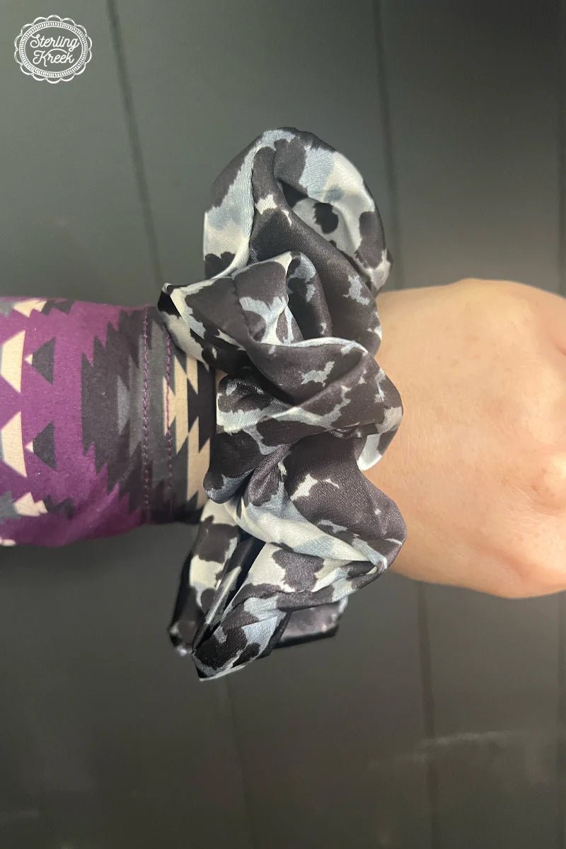 Snag the perfect accessory for your next night on the town (or the farm!) with the Cow Town Scrunchie! Get a moo-valous look with this fun cow print scrunchie, ready to step up your style game and put the herd to shame!  OUTTER WIDTH: 5"  INNER WIDTH: 1.5"