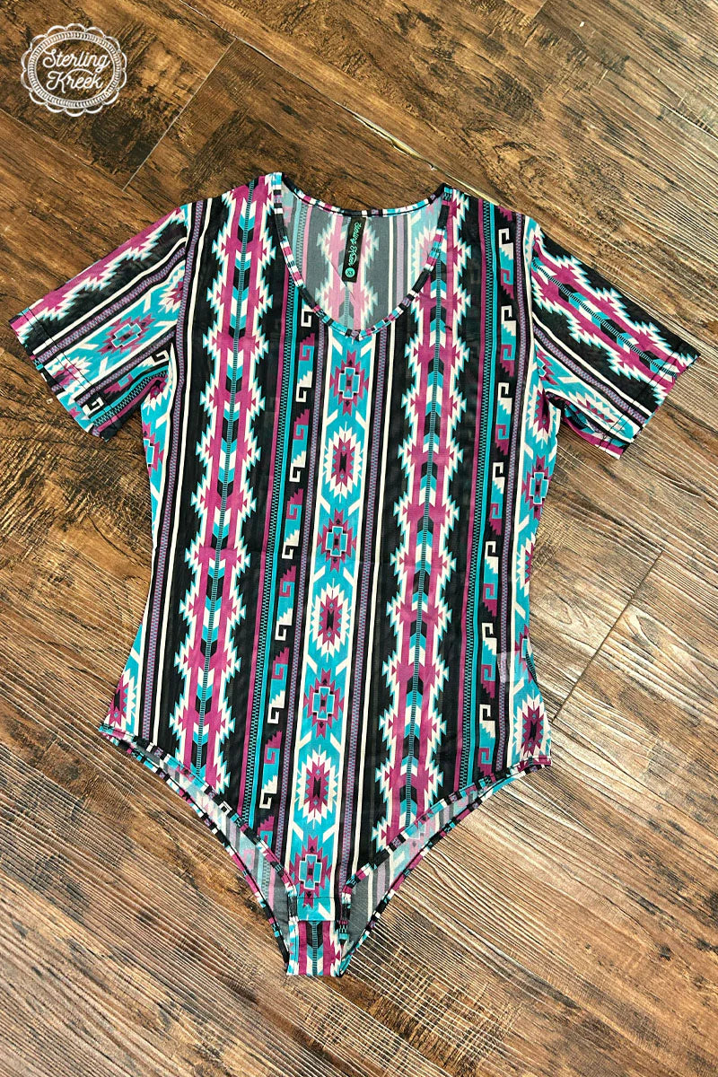Our TAKE IT EASY BODYSUIT is the perfect way to stay stylish and comfy all day long! Made with a breathable mesh fabric and eye-catching Aztec pattern, it's sure to be your go-to when you just wanna kick back, relax, and take it easy. (Hey, now there's an idea!)  94% POLYESTER 6% SPANDEX  LENGTH IS MEASURED FROM TOP OF THE BODY SUIT TO THE THREE CASP BUTTONS ON THE BOTTOM. 