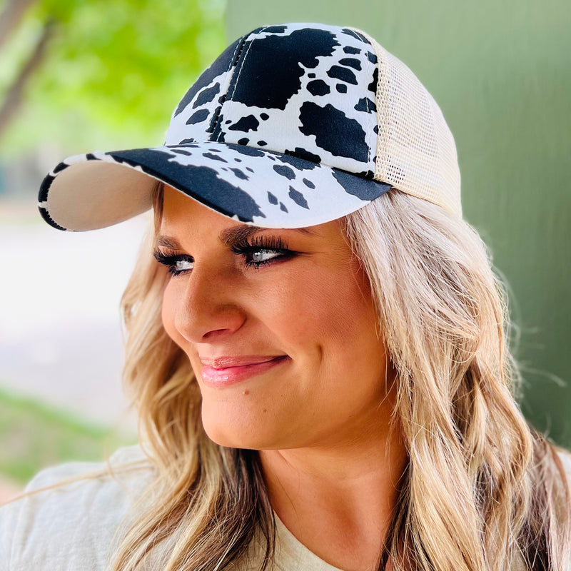 Look like the cow-girl city slicker you always wanted to be with our Cowtown Baseball Cap! This fun accessory features a modern cow print front panel and a tan backing, perfect for a cute cross-over ponytail. Add some country-chic style to your wardrobe with this moo-sical cap!  Velcro Back 