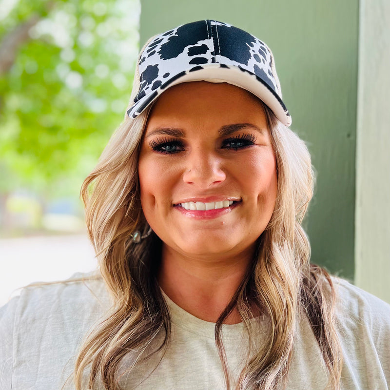 Look like the cow-girl city slicker you always wanted to be with our Cowtown Baseball Cap! This fun accessory features a modern cow print front panel and a tan backing, perfect for a cute cross-over ponytail. Add some country-chic style to your wardrobe with this moo-sical cap!  Velcro Back 