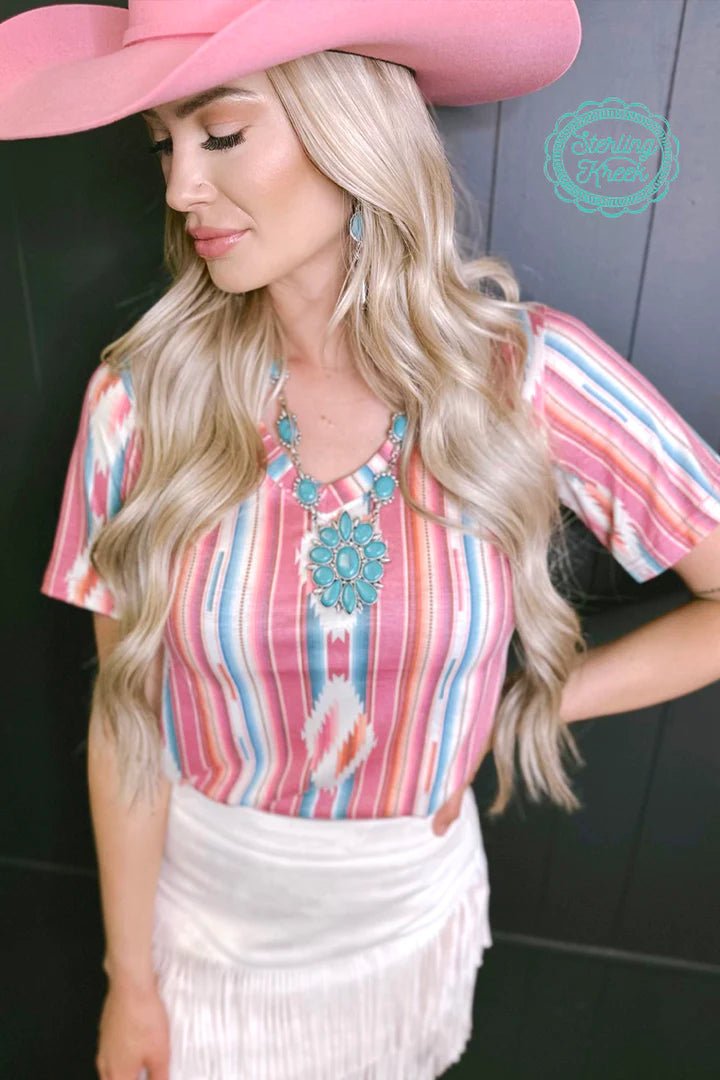Stay cool and stylish in the Frio River Top! This unique top features a faded v-neck and a striking serape/aztec design that will have you standing out from the crowd. Perfect for any summer adventure, this fashionable piece packs a ton of style into a lightweight fabric, just add your favorite denim and you'll be ready to go!  94% modal, 6% spandex