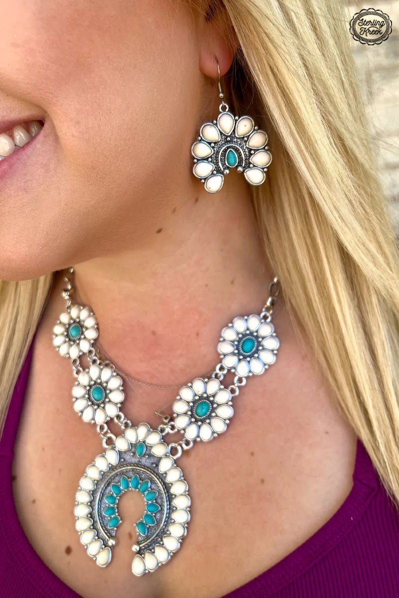 Be a moon goddess with the Selene Earrings! These beautiful danglers feature a white concho charm and a shimmering turquoise stone that will take your look to the next level. With a mix of subtle elegance and eye-catching style, these earrings will have everyone star-struck!  Dont forget to add the matching necklace and bracelet! (sold separately)