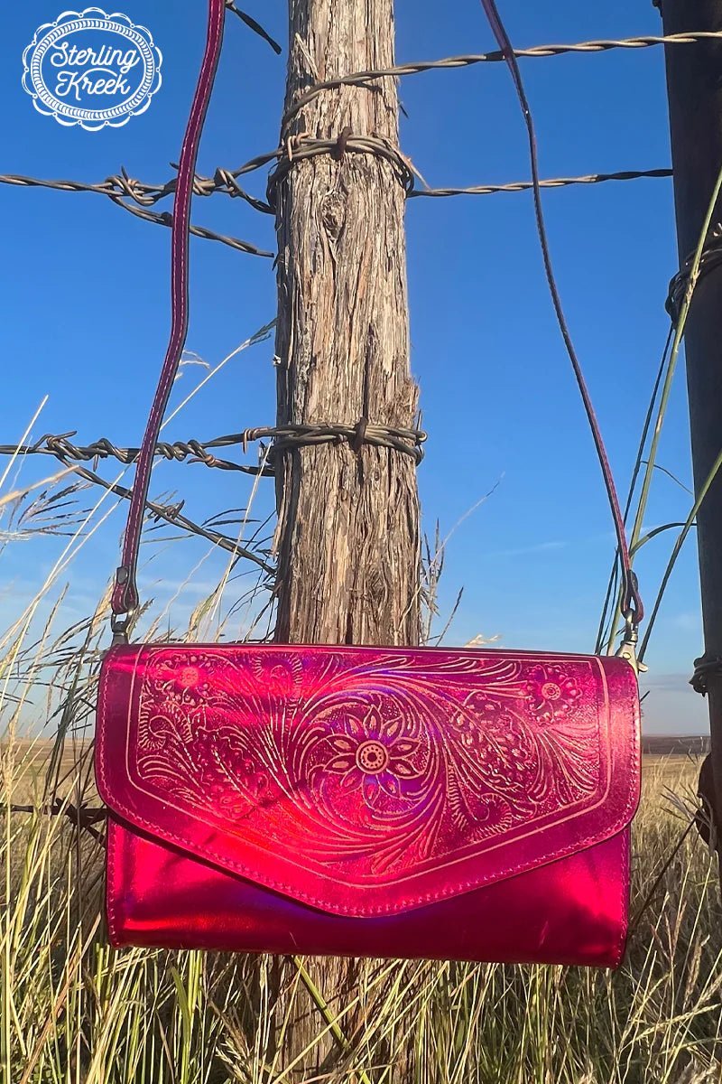 This Metallic Punch Clutch is for the lady with a bit of sass! With a pink metallic exterior and a tooled envelope top design, it'll give your look a punch of style you can take to the streets. Be bold and add a bit of shine to your day with this fabulous accessory!  8.5" X 5" X 2"  Strap : 54"