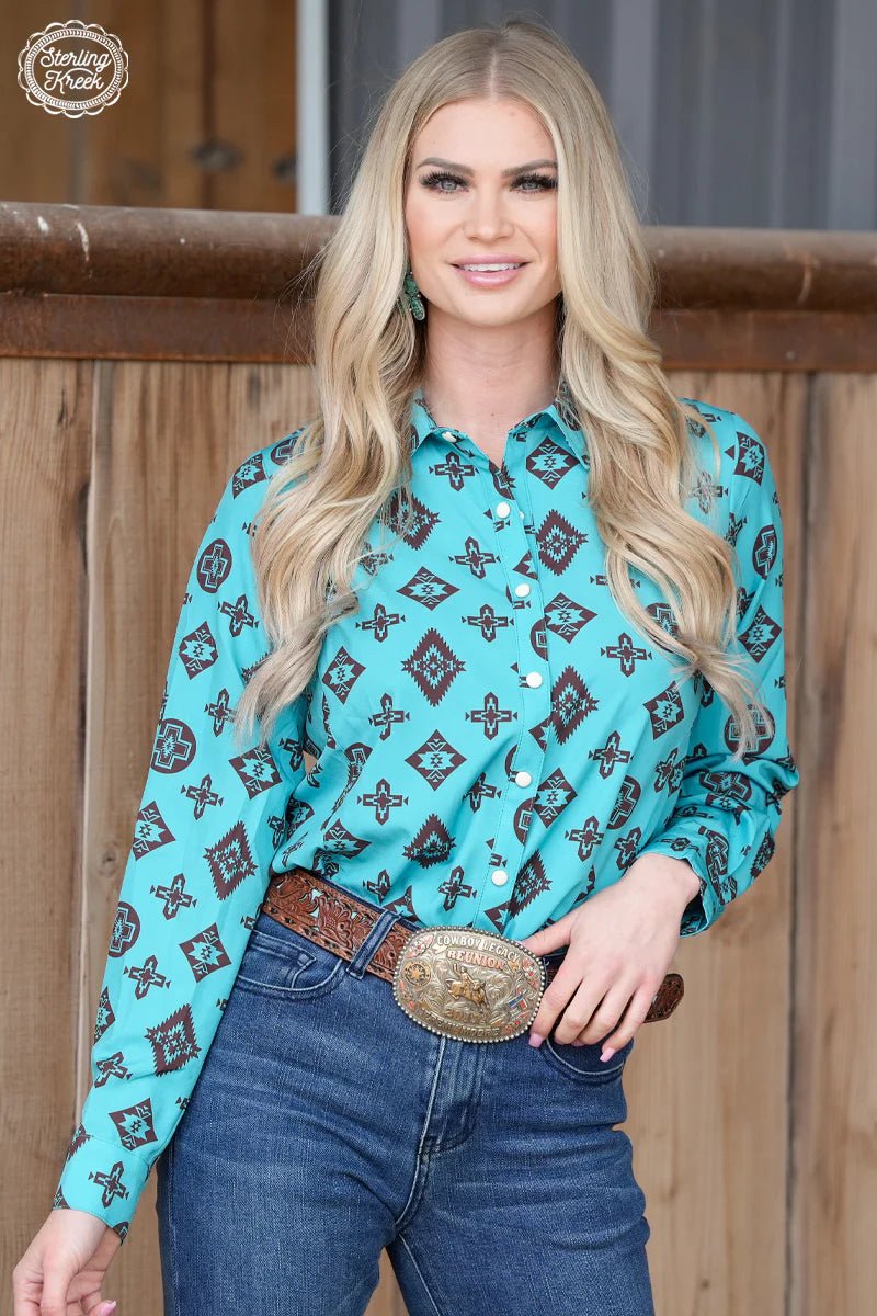 Women's western wear. Women's western button up. Women's western pearl snap. Western style. Turquoise button up. Aztec button up. Western long sleeve button up top. Women's rodeo wear. Rodeo style. Western outfit. Women's western boutique. Boutique. Online boutique. Small business. Woman owned. 