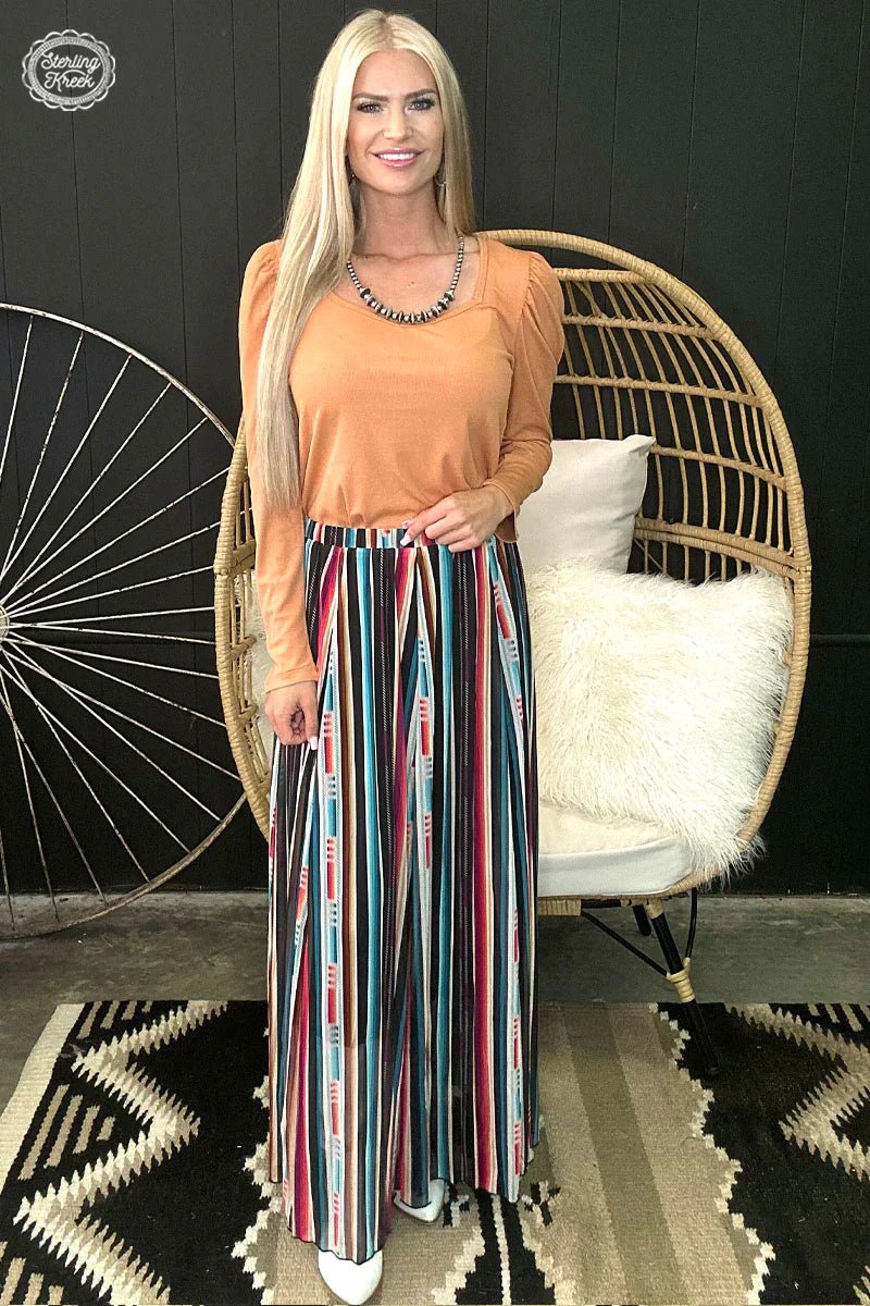 Make a statement in the Serape Kreek Maxi Skirt! This eye-catching garment features a vibrant serape print that’s sure to turn heads. Whether you’re headed to a summer fiesta or just living your best life, this showstopper is sure to make you feel a million bucks!
