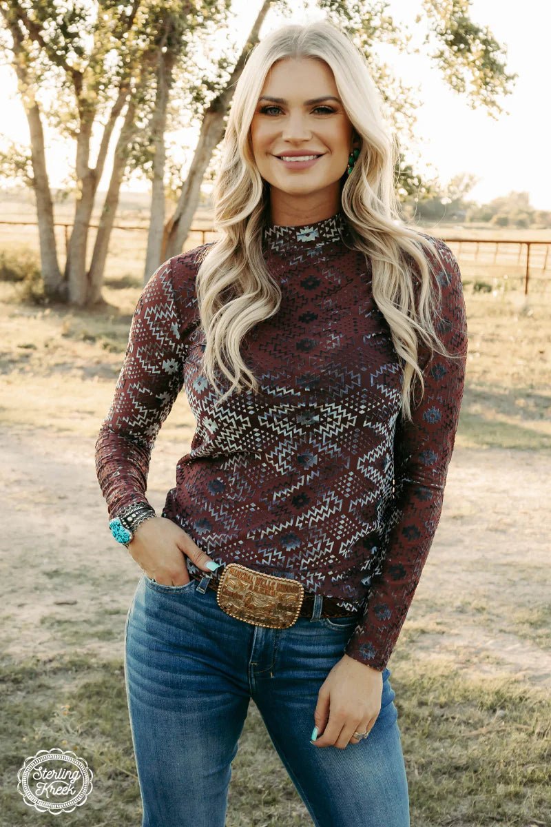 Ease into the holiday season in style with the Sleigh All Day Top! This deep wine colored long sleeve mesh top is made extra festive with a stunning silver velvet aztec embellishment design. Whether you're meeting up with old St. Nick or just trying to stay cozy, this top will keep you riding in comfort and style all season long. Sleigh all day!  96% POLYESTER 4% SPANDEX