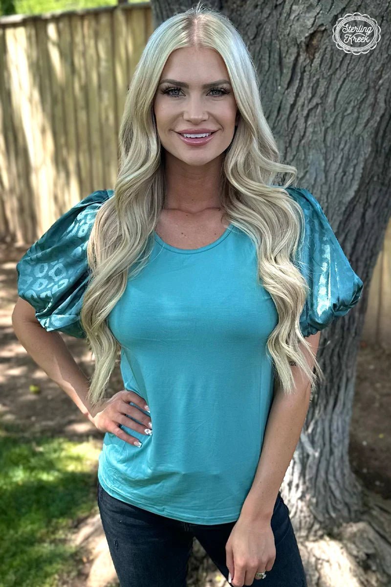 Look wild in the teal cheetah Louisiana Woman Top! This fashion-forward top features luxurious bubble sleeves, ensuring that you make a statement wherever you go. Rock this unique style and let the world know you mean business!